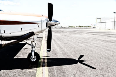 Airplane on airport runway against sky