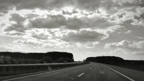 Empty road against cloudy sky