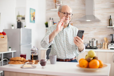 Midsection of man holding ice cream on table