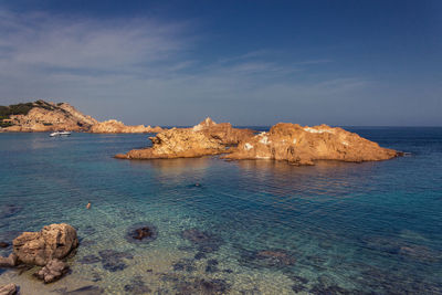 Scenic view of rock formation in sea against sky