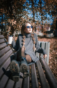 Young woman sitting on bench in park