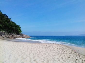 Scenic view of beach against clear blue sky