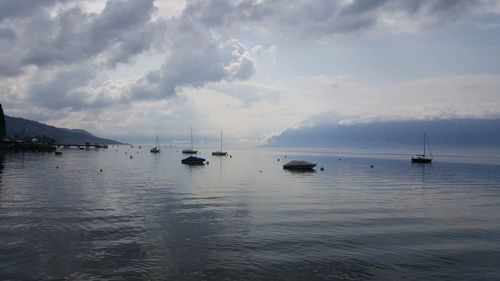 Sailboats in sea against sky