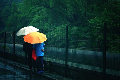 Couples with umbrella on road during rainy season