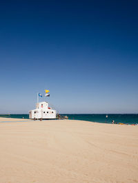 Scenic view of beach against clear blue sky