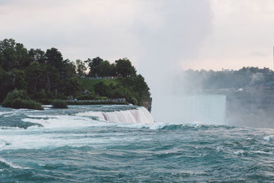 Scenic view of waterfall against sky