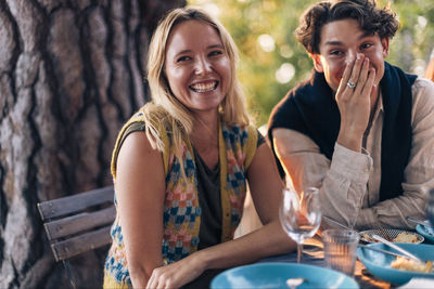 Happy male and female laughing together at dinner party