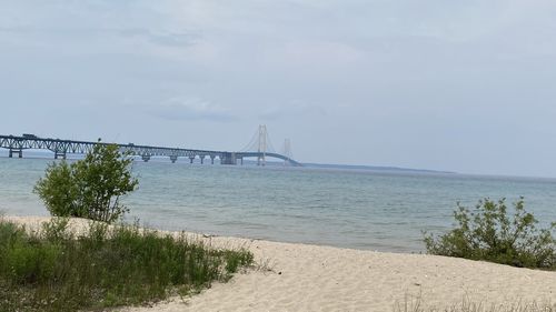 Bridge over calm sea against sky