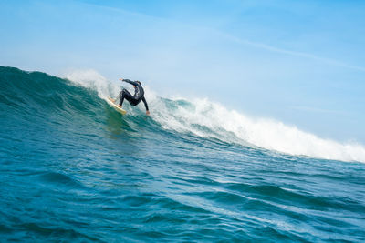 Man surfing in sea against sky