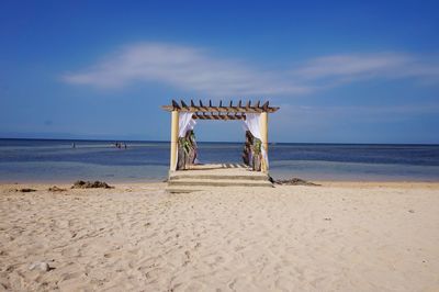 Lifeguard hut on beach against sky