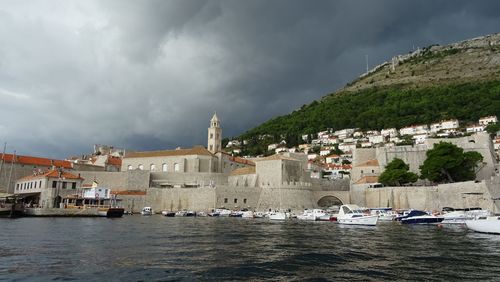 View of buildings by sea against sky