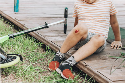 Child's leg injury. child injured knee when he fell off the scooter. dried blood, scratched skin.