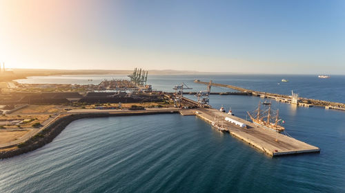 High angle view of city by sea against sky