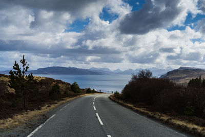 Empty road along landscape and mountains against sky