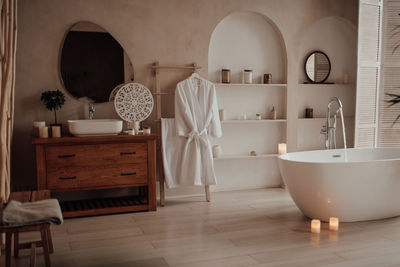 Luxury interior of big bathroom at modern african style with oval bathtub in natural lighting