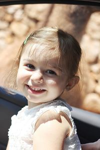 Close-up portrait of cheerful girl in car