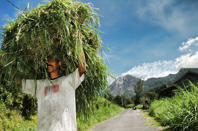 Young woman in farm against sky