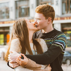 Young couple embracing while standing outdoors