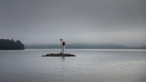 Lighthouse on sea against sky