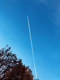 Low angle view of vapor trail against blue sky