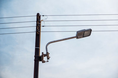 Low angle view of electricity pylon against sky