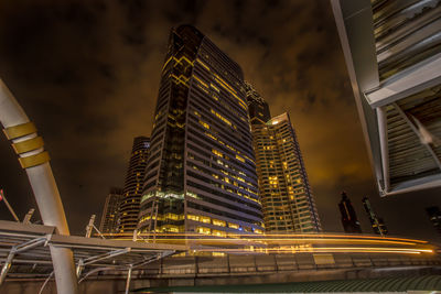 Low angle view of illuminated buildings against sky at night