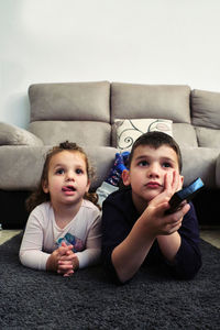 Siblings watching a home movie while eating popcorn