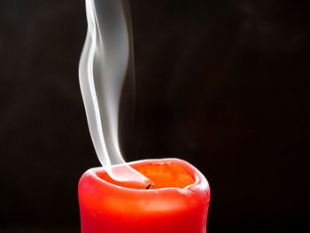 Close-up of candle against black background