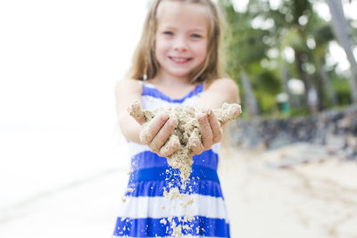Close-up of smiling girl playing at beach