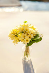 Close-up of yellow flower vase on table