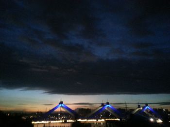 Low angle view of illuminated building against cloudy sky