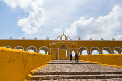 Rear view of people on bridge against sky