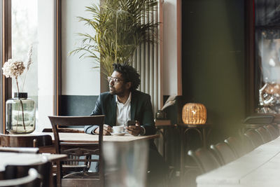 Young woman sitting on table in restaurant
