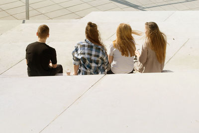 Rear view of people sitting on stairs