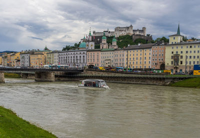 Arch bridge over river against buildings in city