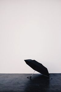 High angle view of black umbrella over white background