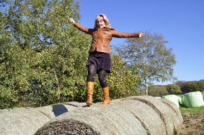 Full length of woman walking on hay bales