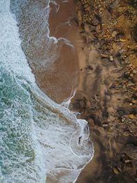 Aerial view of waves splashing at shore