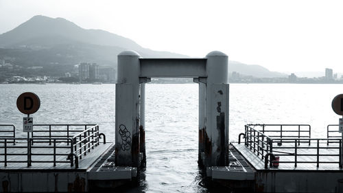 Railing by sea against clear sky