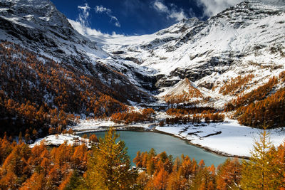 Scenic view of snowcapped mountains and lake during autumn