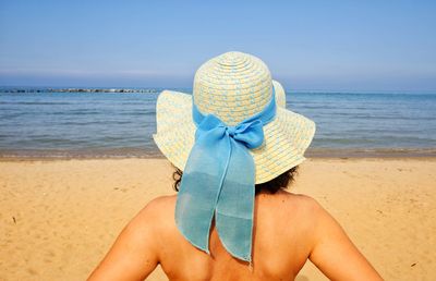 Rear view of person wearing hat on beach
