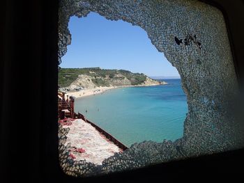 Panoramic view of sea against clear blue sky seen through window