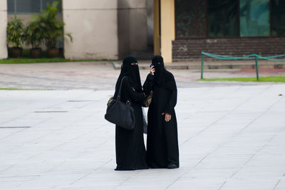 Women in burka standing on road