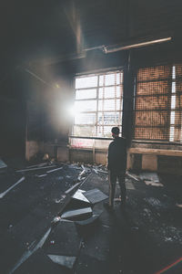 Rear view of man standing in abandoned building