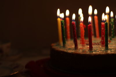 Close-up of illuminated candles on birthday cake