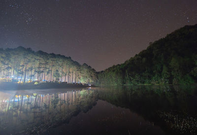 Scenic view of lake against sky at night