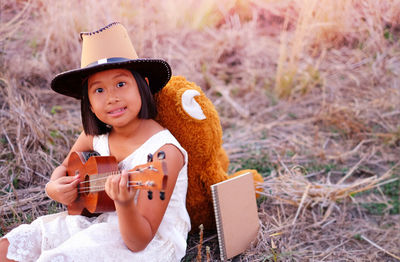Portrait of cute girl playing guitar