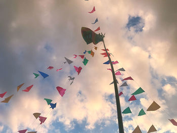 Low angle view of kites flying against sky