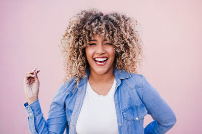 Portrait of young woman with curly hair against white background