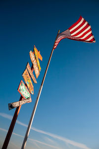 Low angle view of flag against clear blue sky